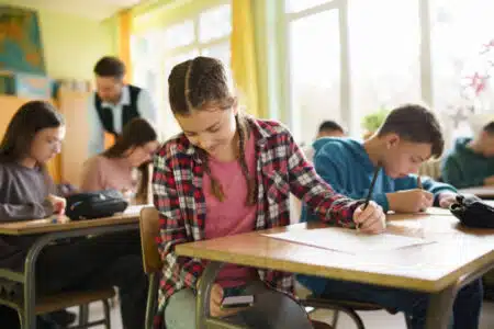 Teenage Girl Using A Smart Phone During An Exam In The Classroom