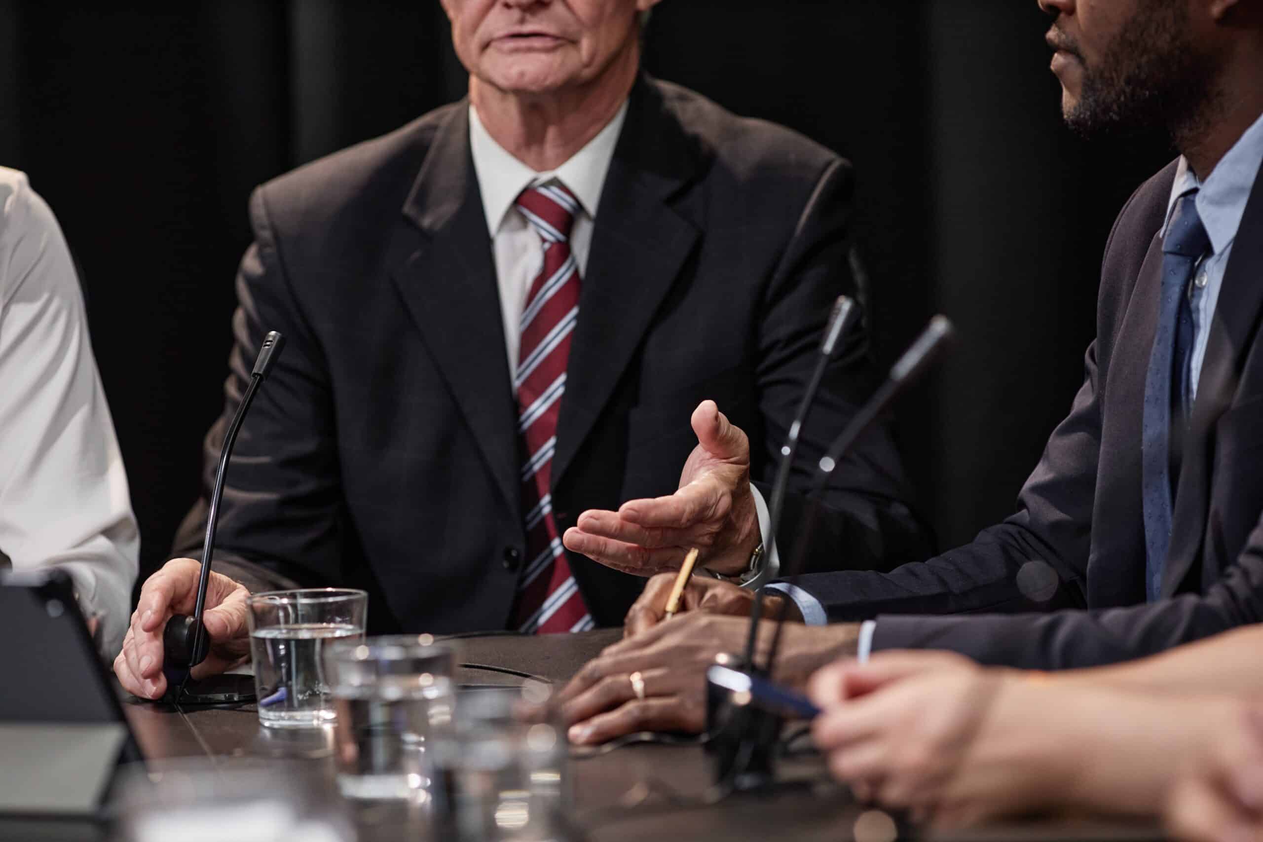 Cropped,shot,of,senior,politician,in,suit,talking,to,colleagues